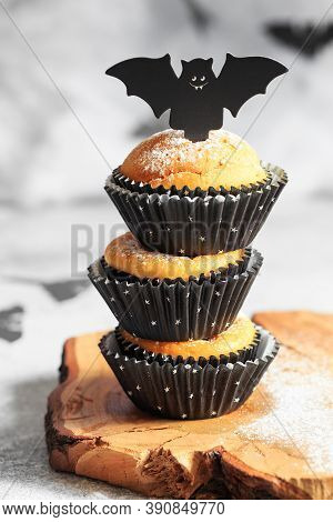 Halloween Pumpkin Muffins In Black Capsules Decorated With Cardboard Bats. Festive Halloween Cupcake