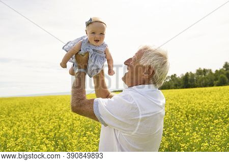 Grandfather Spending Time With Little Baby Girl During The Day