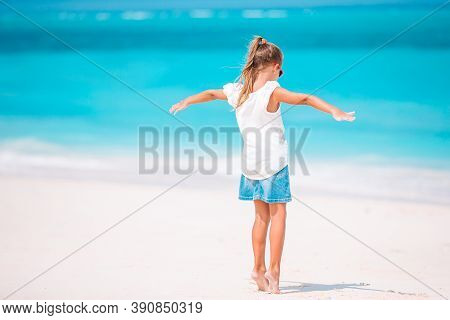 Adorable Active Little Girl At Beach During Summer Vacation