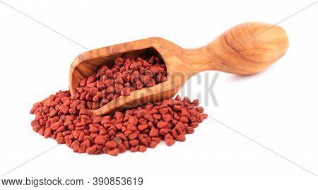 Annatto Seeds In Wooden Scoop, Isolated On White Background. Achiote Seeds, Bixa Orellana. Natural D