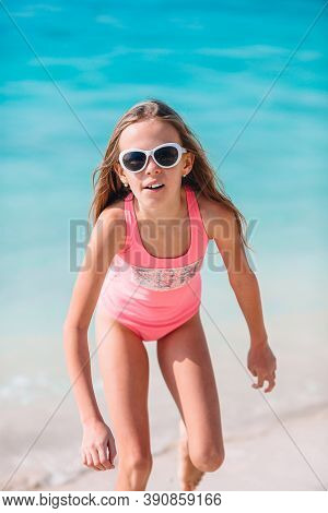 Adorable Active Little Girl At Beach During Summer Vacation