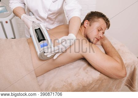 Male Patient Receiving Endospheres Massage At Beauty Clinic. Cosmetologist Massaging Back Of A Clien