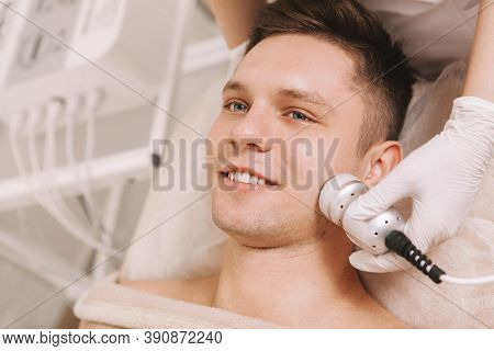Happy Handsome Man Having Skincare Treatment By Professional Cosmetologist