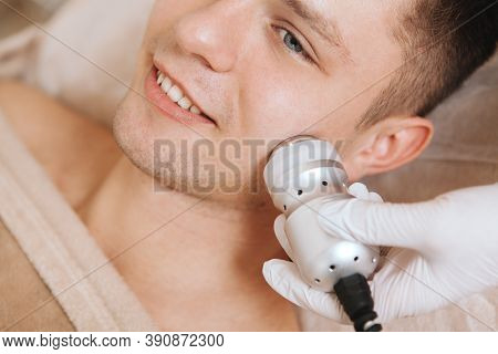 Cropped Close Up Of A Young Man Smiling While Getting Facial Hardware Procedure At Beauty Clinic