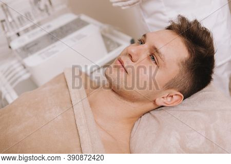 Close Up Of An Attractive Young Man Relaxing At Beauty Salon Before Skincare Treatment