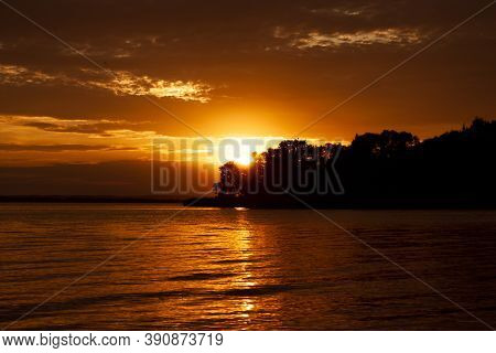 Horizontal Landscape Photo Of An Orange Sunset Over The Sea With Dark Silhouette Of Unknown Island, 