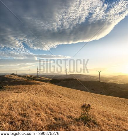 wind turbines on ridge of mountains in Sicily at the sunset