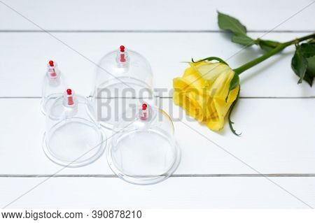 Jars For Hijama On A White Wooden Background And Yellow Flowers. Bloodletting. Sunnah Treatment. Isl