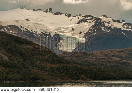 Sarmiento Channel, Chile - December 11, 2008: Fjord And Amalia Glacier Above Belt Of Brown Rocks And