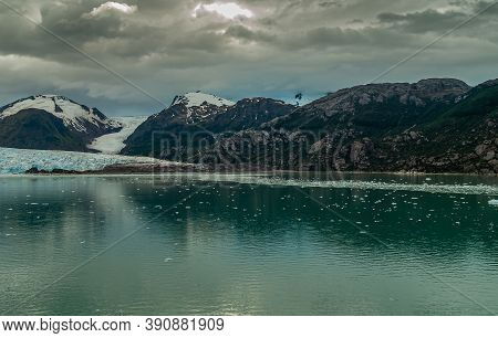Sarmiento Channel, Chile - December 11, 2008: Amalia Glacier. Ice Pieces Float In Green Melt Water R