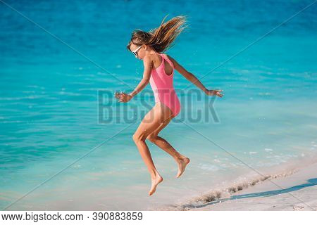 Adorable Active Little Girl At Beach During Summer Vacation