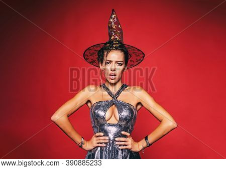 Pretty Woman In Witch Costume At Halloween Party. Surprised Woman With Beautiful Face And Retro Hair