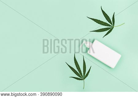 Jar With Cosmetic Product, Gel Or Shampoo With Cannabis Oil On Green Colored Background. White Flack