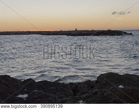 View Of The Sea And Stones On The Pedregalejo Beach At Dusk