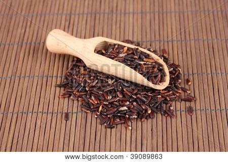 arroz preto com colher de madeira em esteira de bambu