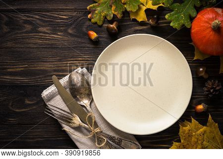 Thanksgiving Food Concept. Autumn Table Setting With Craft Plate, Silverware And Fall Decorations At