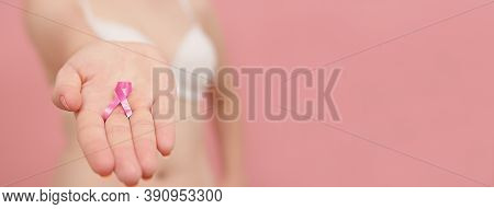 Pnk October, Brest Cancer Awareness Ribbon In The Hand Of A Young Unrecognzable Woman. High Quality 