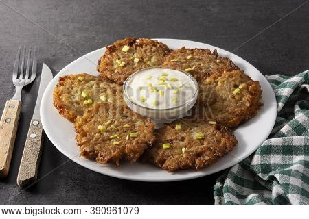 Traditional Jewish Latkes Or Potato Pancakes On Black Background