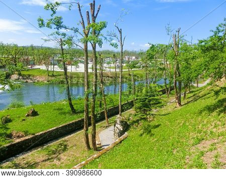 View On Waterfall, Mill In White Building, Pedestrian Bridge In Park Postojna Jama Near Postojna Cav