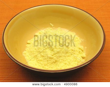 Cornmeal ในชามเซรามิคบนพื้นหลังเป็นสีส้ม