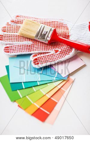 concetto di ristrutturazione casa e interior design - pennello, guanti e pantone campionatori