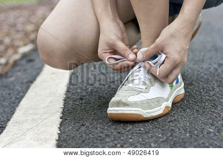 Runner tying running shoes getting ready for jogging