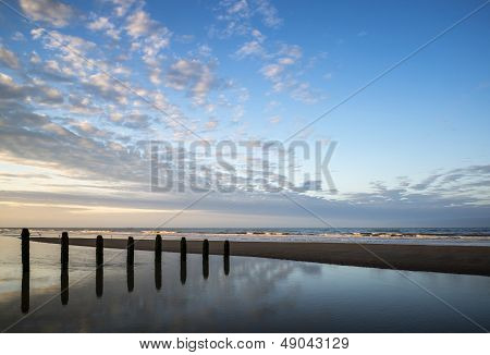 Vibrant Sunrise Landscape Reflected In Low Tide Water On Beach