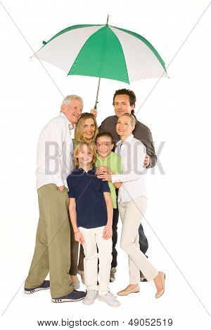 Three Generations Family Standing Isolated On White Background Holding Umbrella