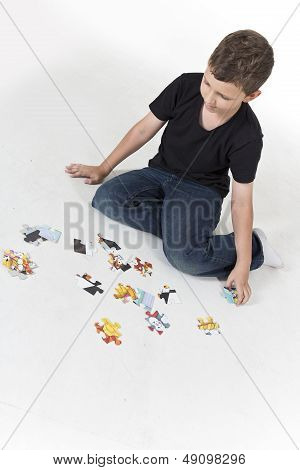 Young boy is putting puzzle together