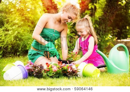 Mother and daughter planting flowers together