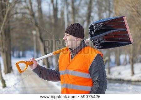 Man with a snow shovel on the sidewalk
