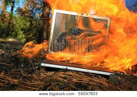 A genuine Lap Top Computer completely engulfed in flames of fire.  Computer damage due to a person typing so fast they burned up the internet or were writing something so HOT it literally caught fire
