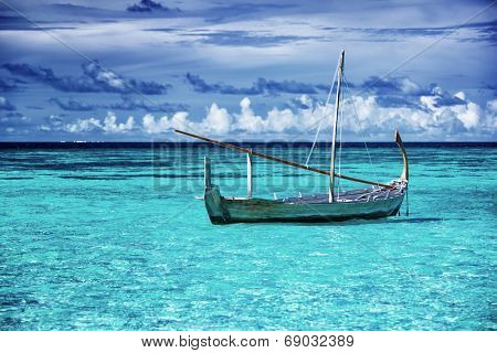Little fishing boat in blue sea, beautiful peaceful seascape background, clear transparent water of Maldives islands