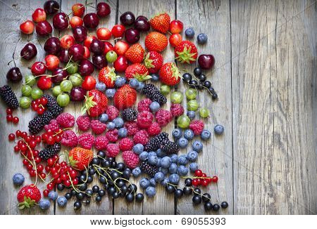 Summer wild berry fruits on vintage board