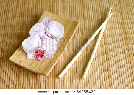 Orchids on bamboo mat abstract asian food concept
