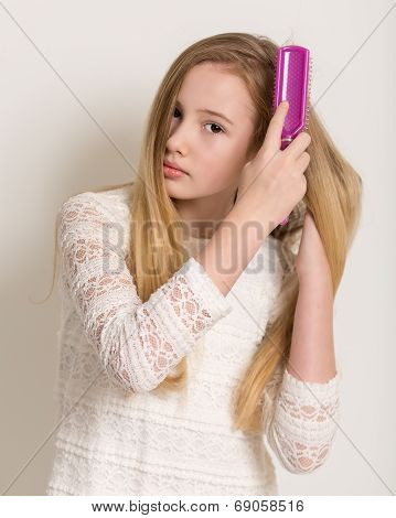 Pretty Young Blond Girl Brushing Her Hair