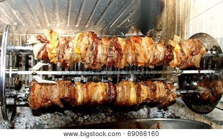 Spit Roast With Meat Cooked In The Fireplace With The Spit To Turn The Pieces Of Meat