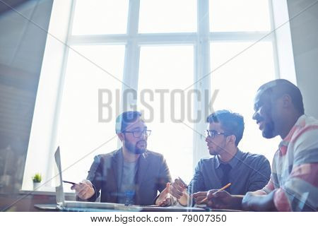 Confident manager presenting new business project to his colleagues in office