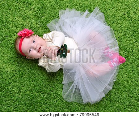 New Born Infant Child Baby Girl Lying Happy Smiling On Green Grass Blanket