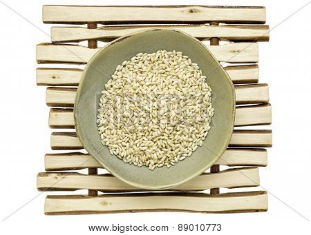 sprouted brown rice in a ceramic bowl on a wood stick trivet