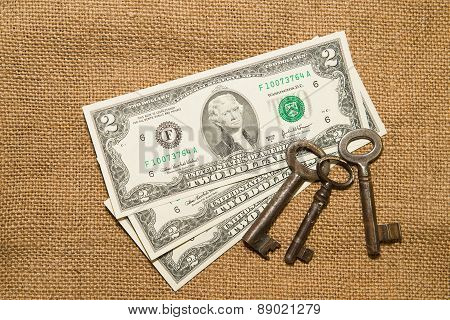 Us Dollar Banknotes And Vintage Keys On An Old Cloth