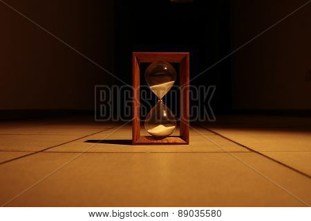 Sandglass in dark corridor