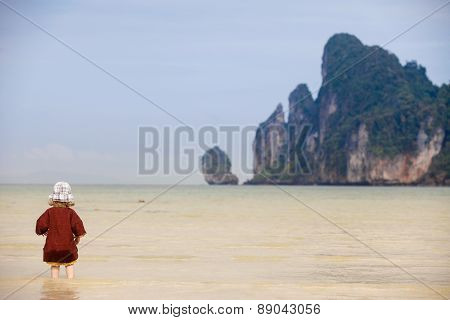 Child Walking On Fine Sand Through The Water