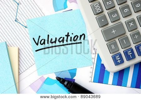 Papers with graphs, calculator and Valuation concept.