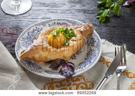 Khachapuri on plate with herbs. Top view
