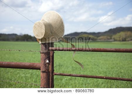 Old Fashioned Straw Bonnet On Fence Post In Texas Hill Country