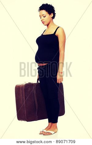 Sad pregnant woman with a lugagge