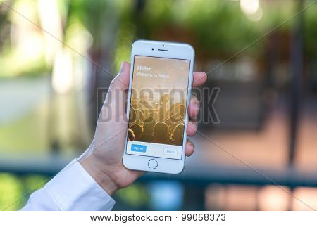 Loei, Thailand - August 12, 2015: Hand holding Iphone with mobile application for twitter on the screen