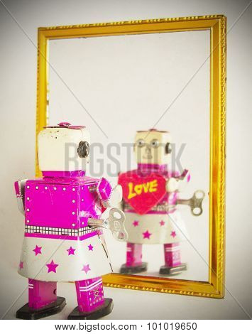 toy robot looking in the mirror
