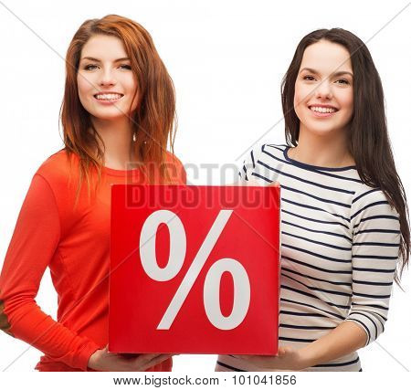 shopping, sale, and gift sconcept - two smiling teenage girls with percent sign on red box